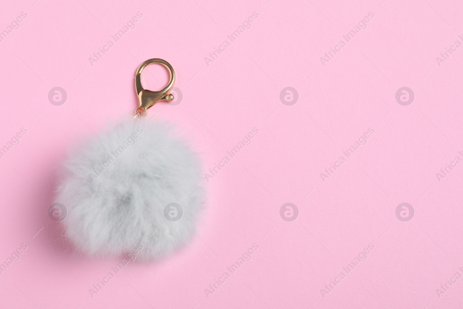 Photo of Gray fur keychain on pale pink background, top view. Space for text