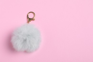 Photo of Gray fur keychain on pale pink background, top view. Space for text