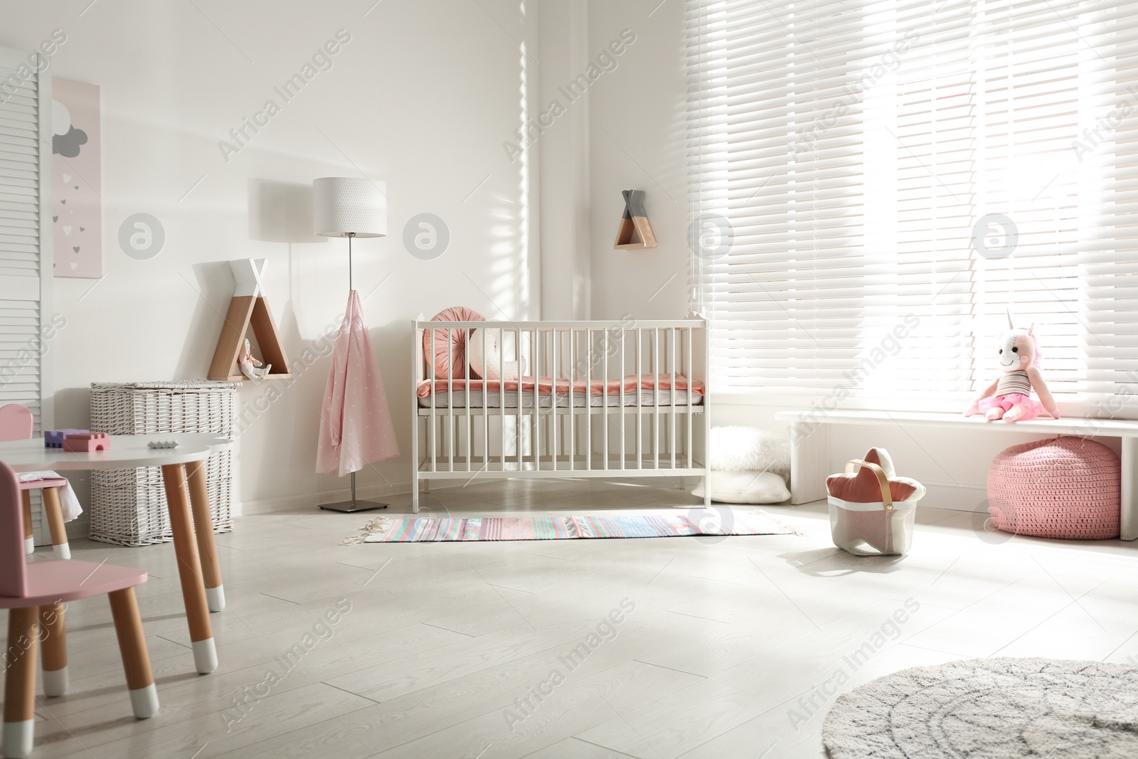 Photo of Cute baby room interior with crib and decor elements