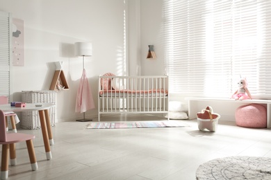 Cute baby room interior with crib and decor elements