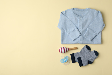 Photo of Flat lay composition with child's clothes and accessories on beige background, space for text