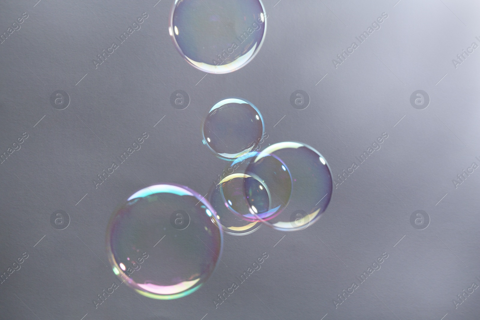 Photo of Beautiful transparent soap bubbles on gray background