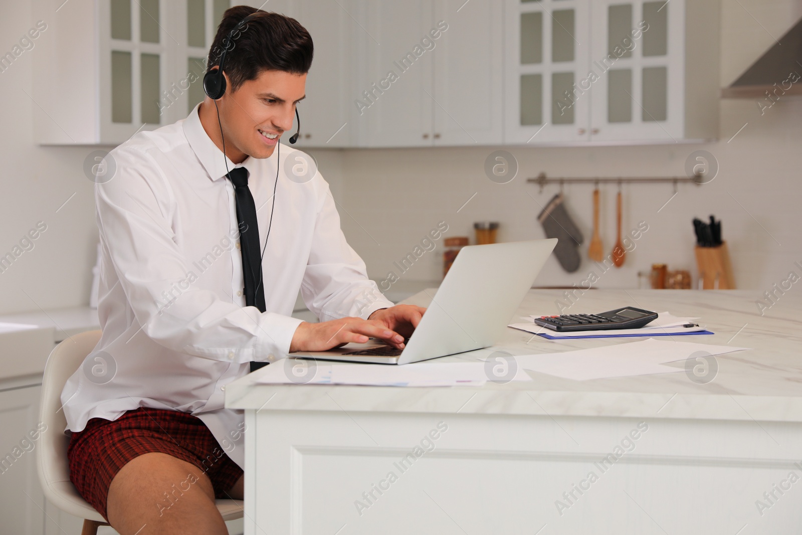 Photo of Man working on laptop in kitchen. Stay at home concept