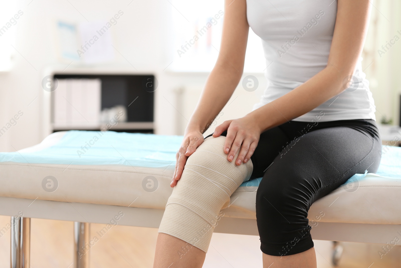 Photo of Woman with bandage on her knee in orthopedist's office, closeup