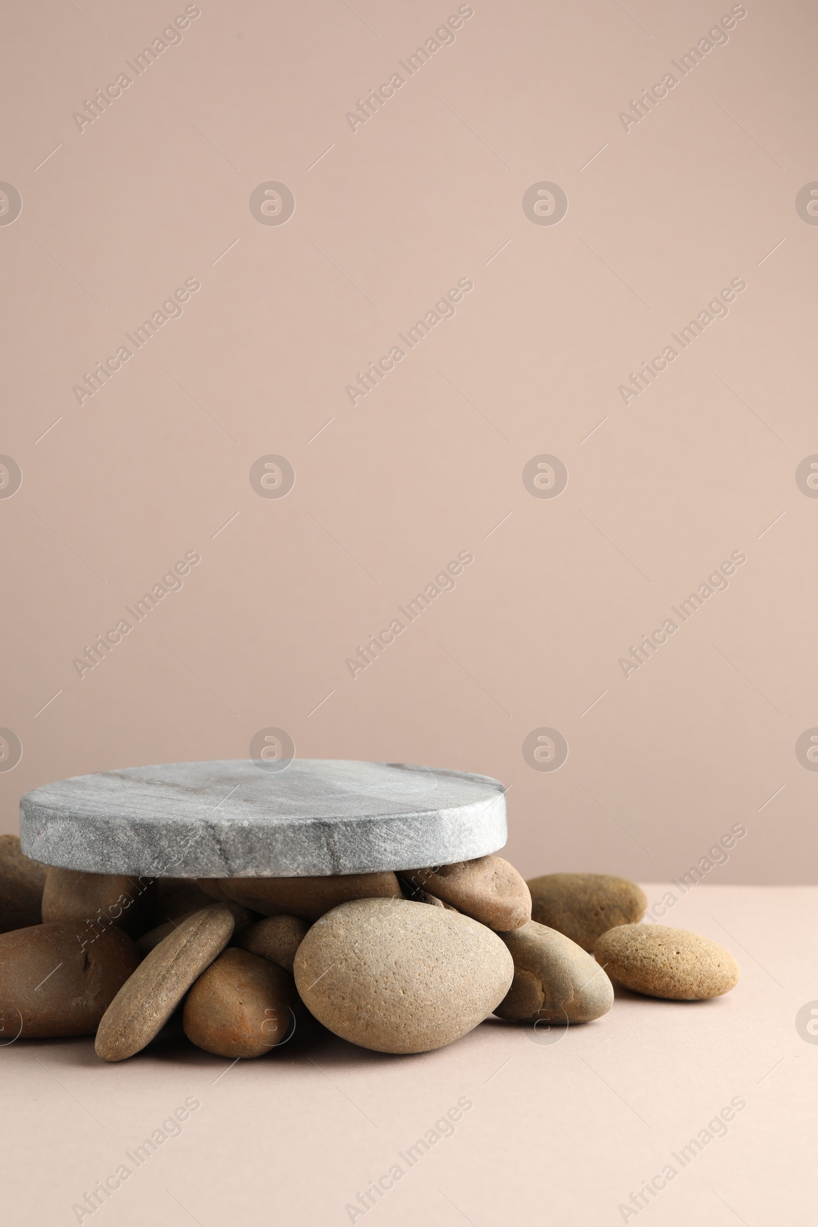 Photo of Presentation for product. Stone podium and pebbles on beige background. Space for text