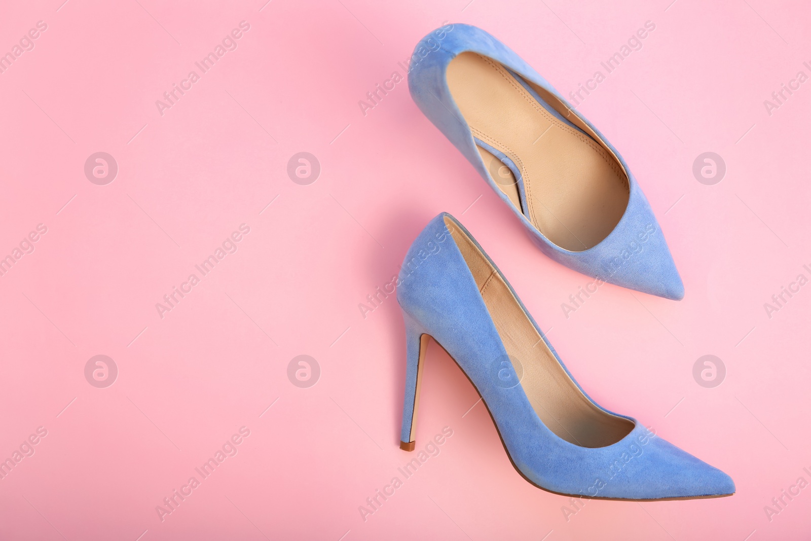 Photo of Pair of female shoes on color background