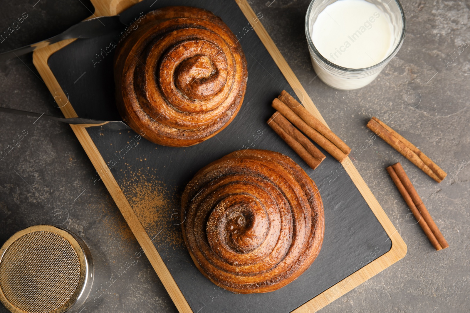 Photo of Flat lay composition with freshly baked cinnamon rolls on grey background