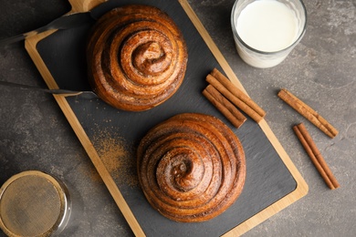 Flat lay composition with freshly baked cinnamon rolls on grey background