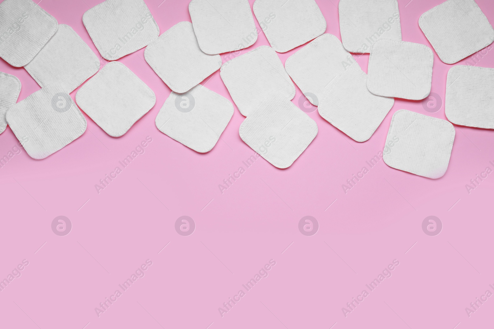 Photo of Many clean cotton pads on pink background, flat lay. Space for text