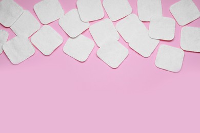 Many clean cotton pads on pink background, flat lay. Space for text