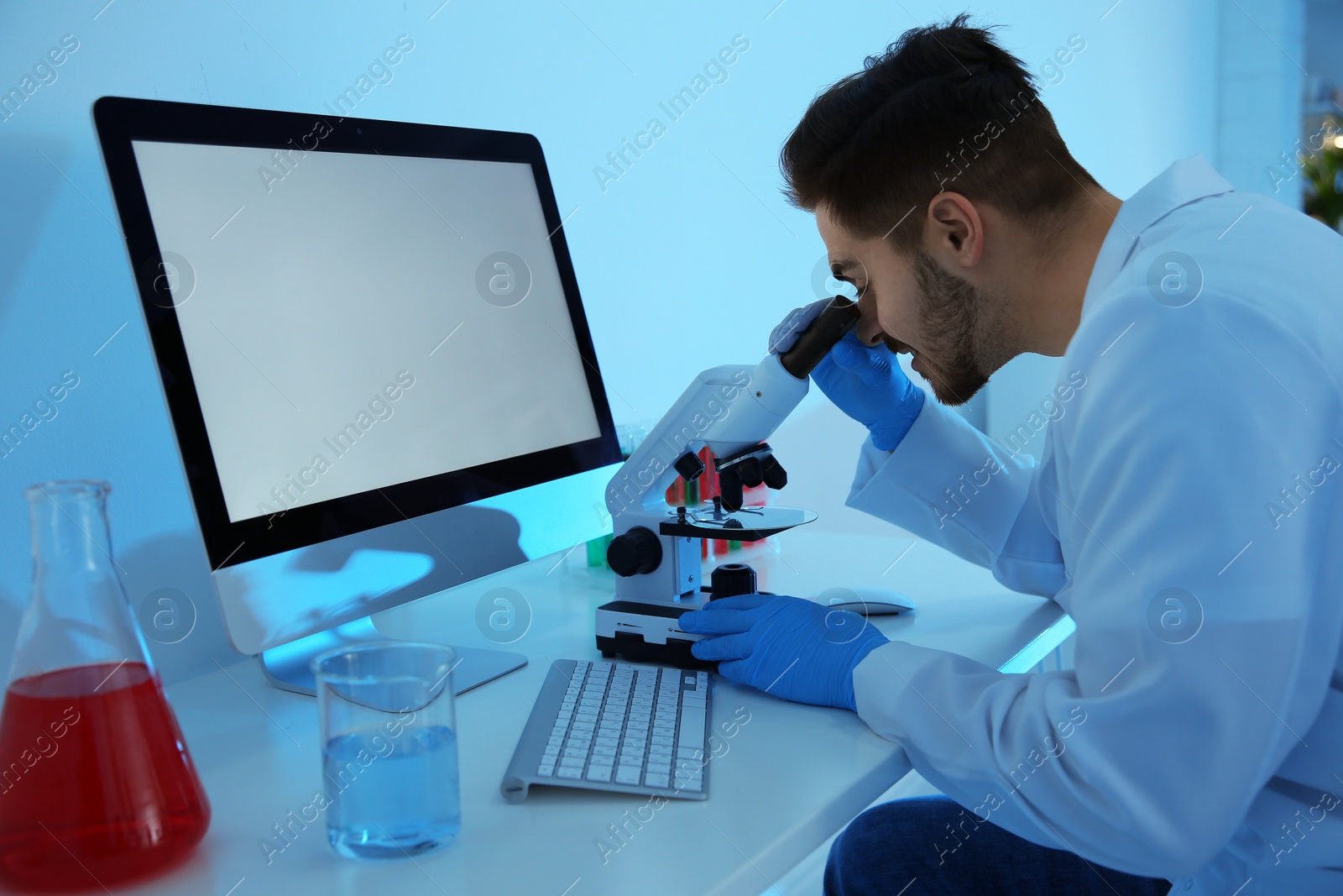 Photo of Medical student working with microscope in modern scientific laboratory