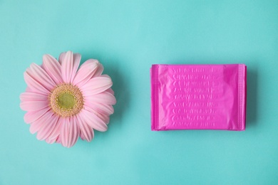 Photo of Flat lay composition with menstrual pads and gerbera flower on color background. Gynecological care