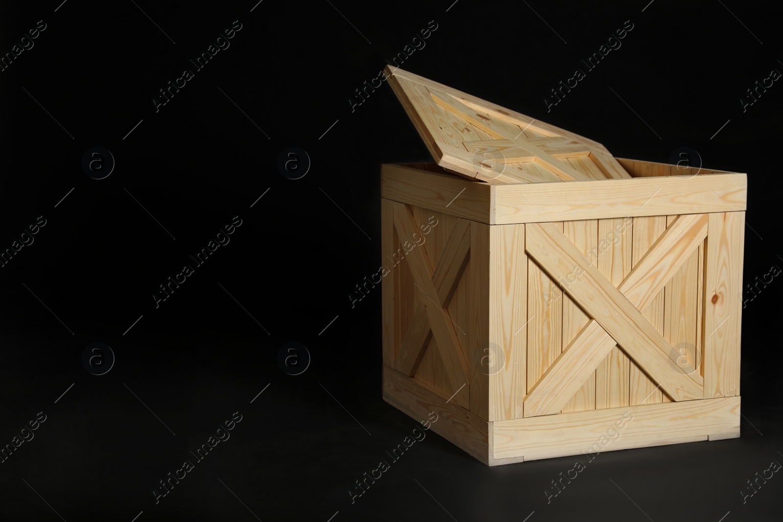 Photo of Wooden crate on black background. Space for text