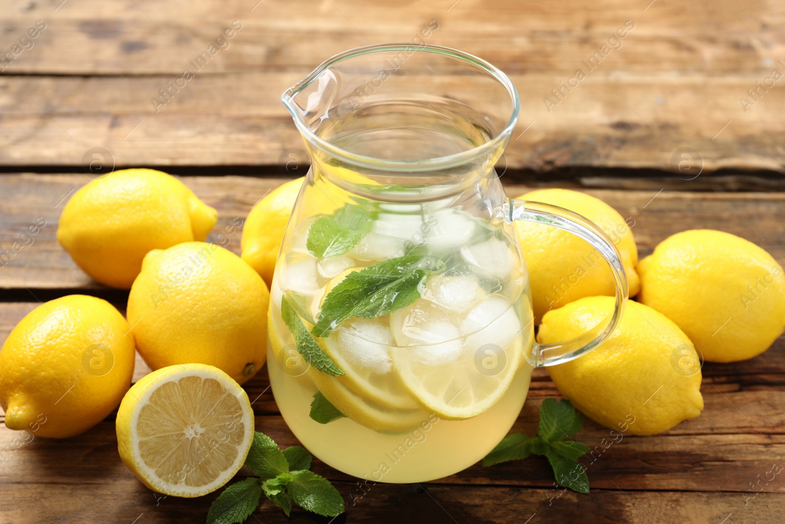 Photo of Natural lemonade with mint and fresh fruits on wooden table. Summer refreshing drink