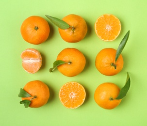 Photo of Composition with tangerines and leaves on color background, flat lay