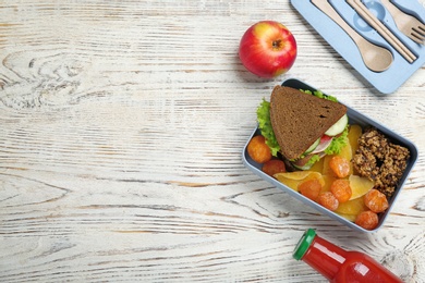 Flat lay composition with lunch box and appetizing food on wooden background