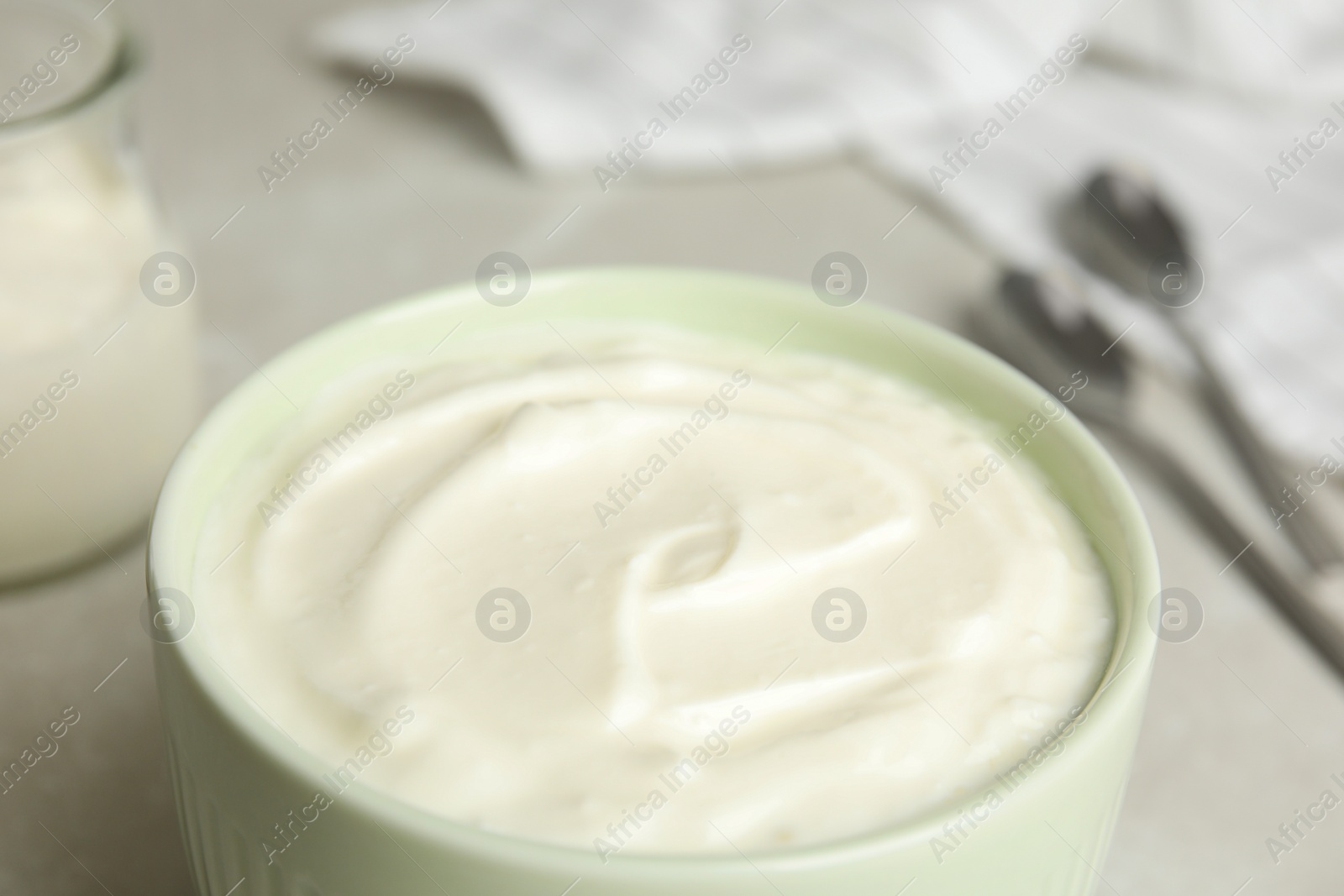 Photo of Tasty organic yogurt in bowl on table, closeup