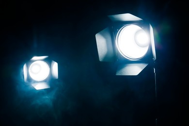 Bright spotlights and smoke in darkness. Professional stage equipment