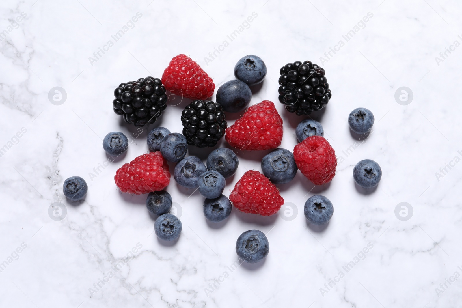 Photo of Many different fresh ripe berries on white marble table, flat lay