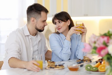 Photo of Happy couple having tasty breakfast at home