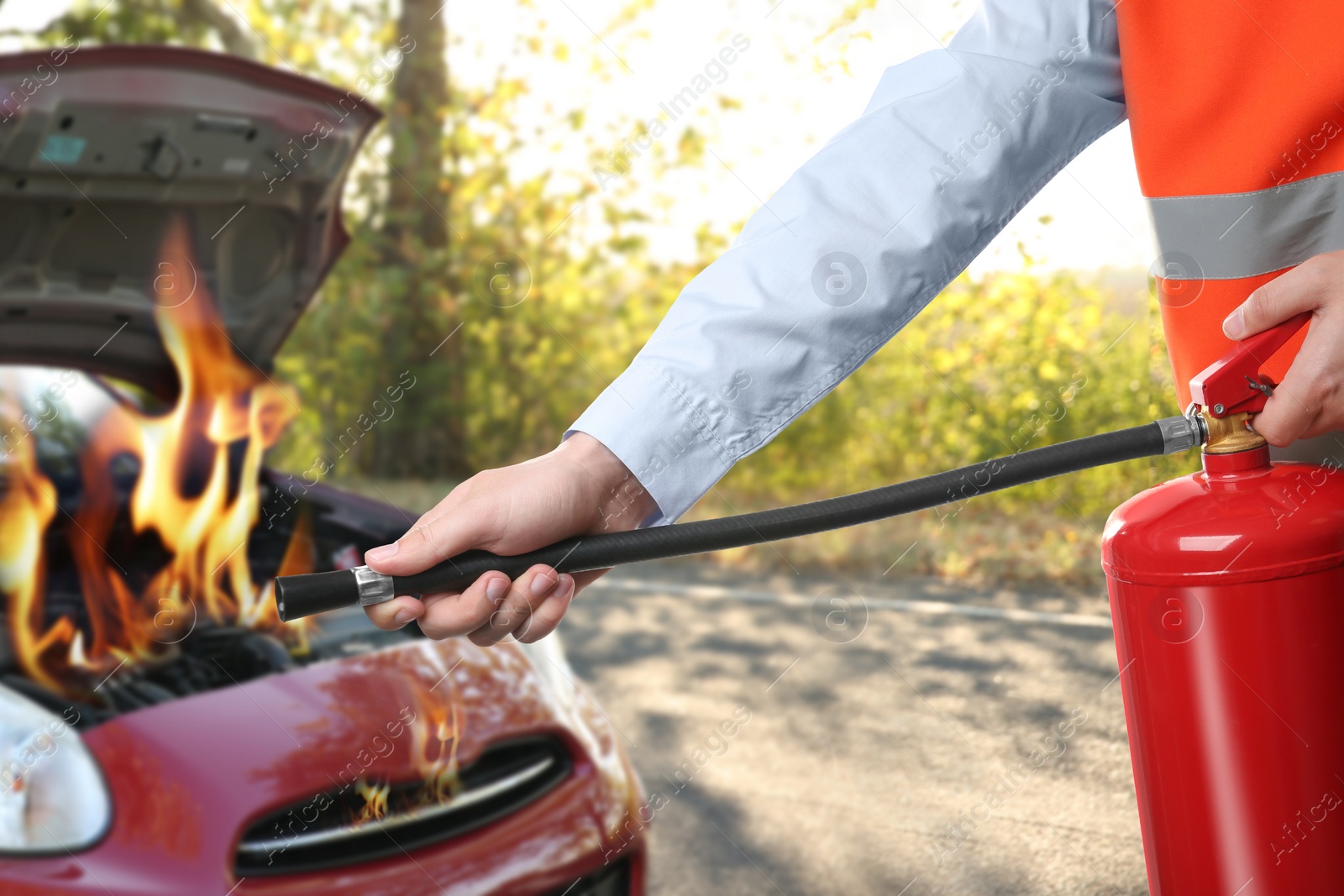 Image of Man with fire extinguisher near car in flame outdoors, closeup