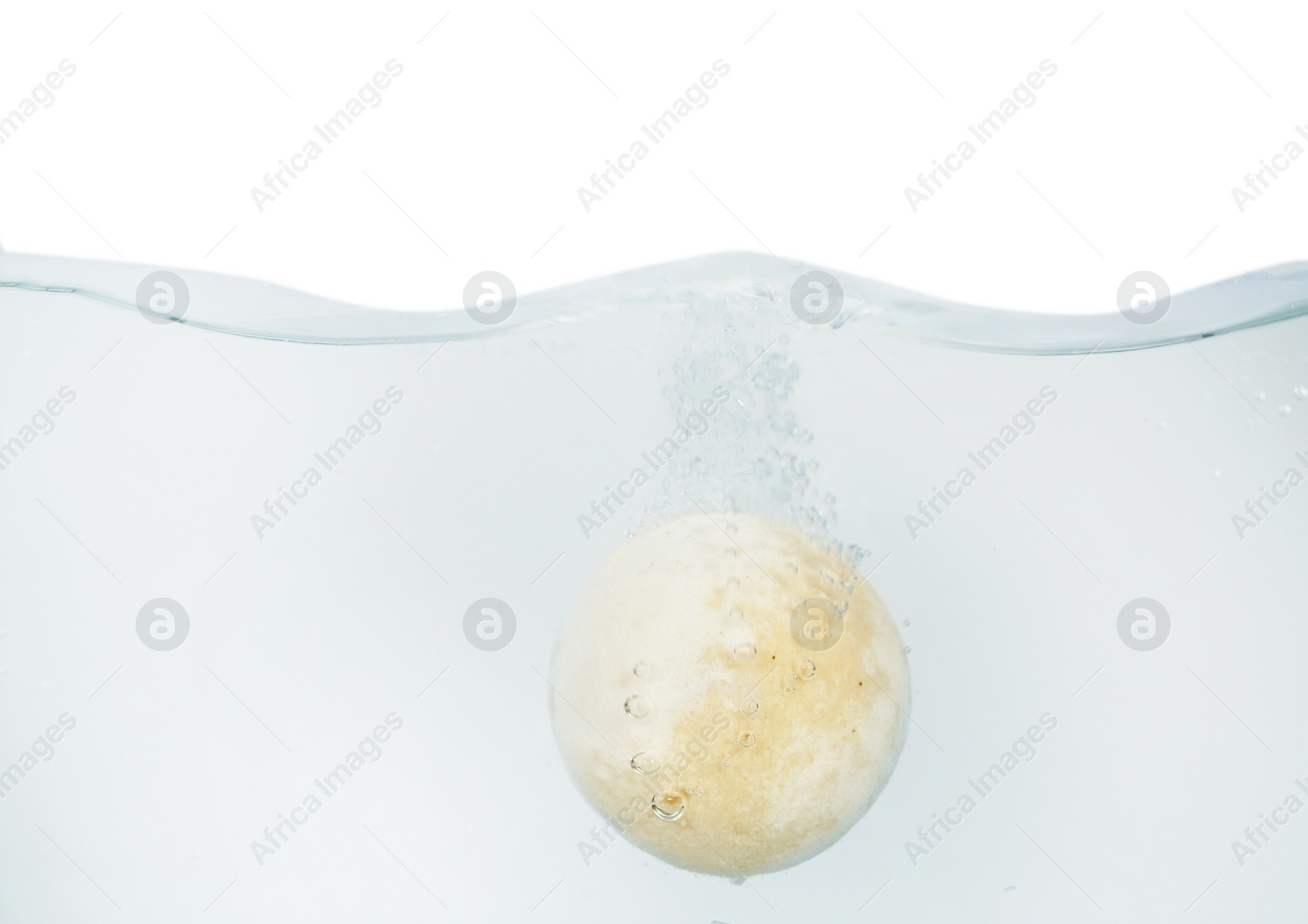 Photo of Bath bomb in water on white background