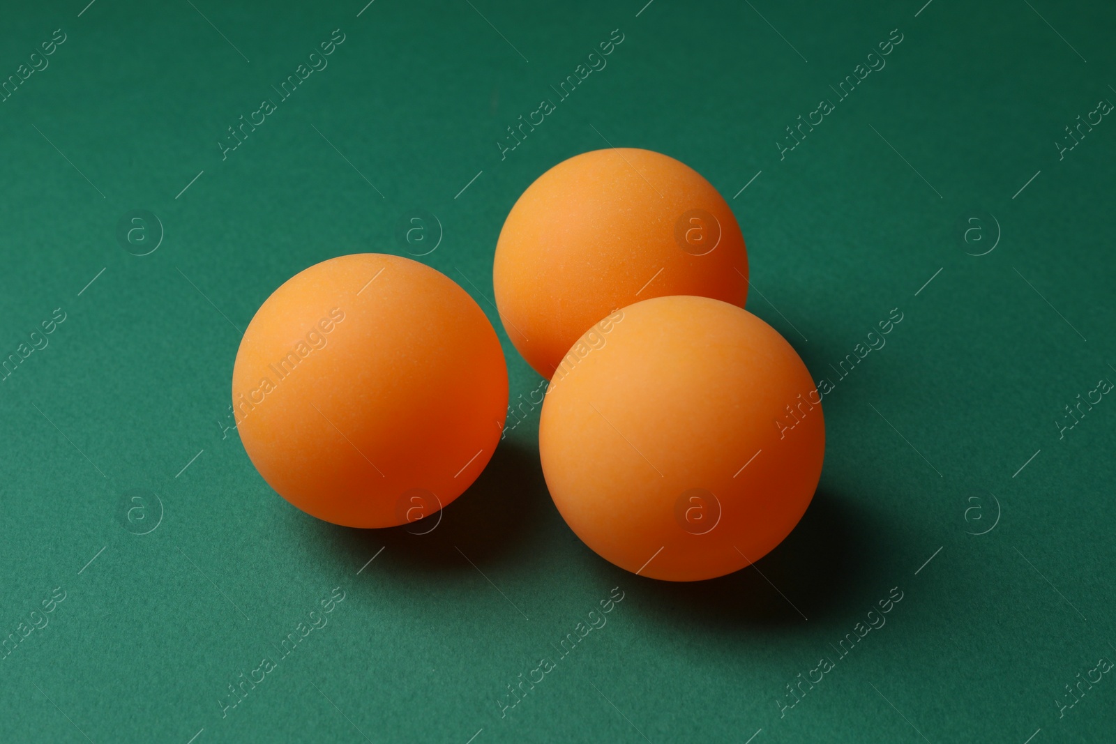 Photo of Three ping pong balls on green background