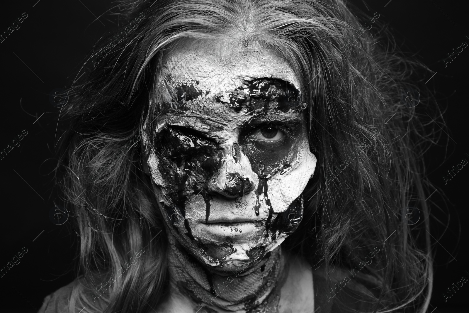 Photo of Scary zombie on dark background, black and white effect. Halloween monster