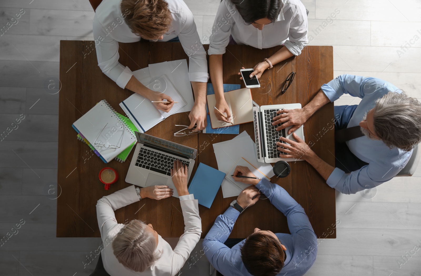 Photo of Business people discussing work matters at table in office, top view. Professional communication