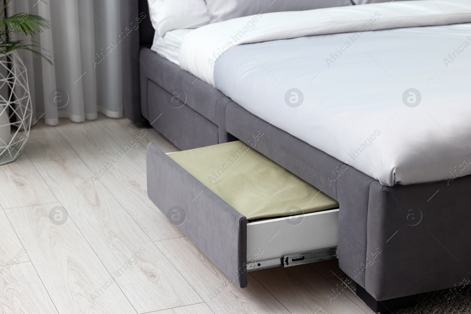 Photo of Storage drawer with bedding under comfortable bed in room