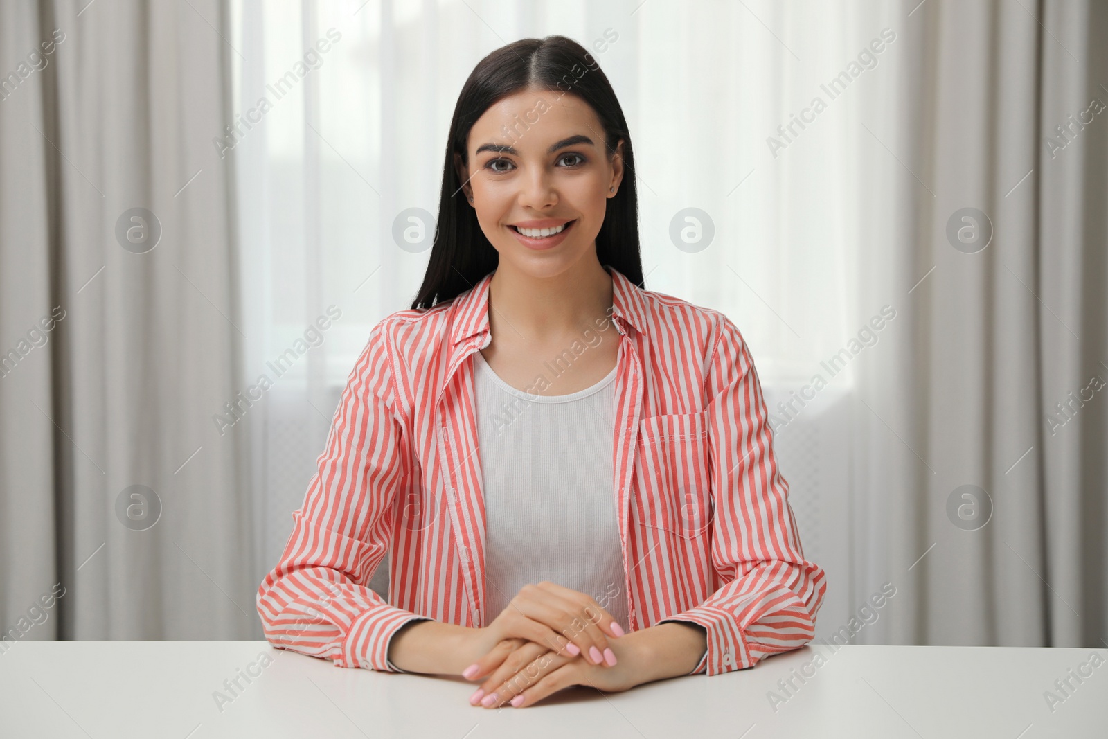 Photo of Beautiful young woman conducting webinar in room, camera view