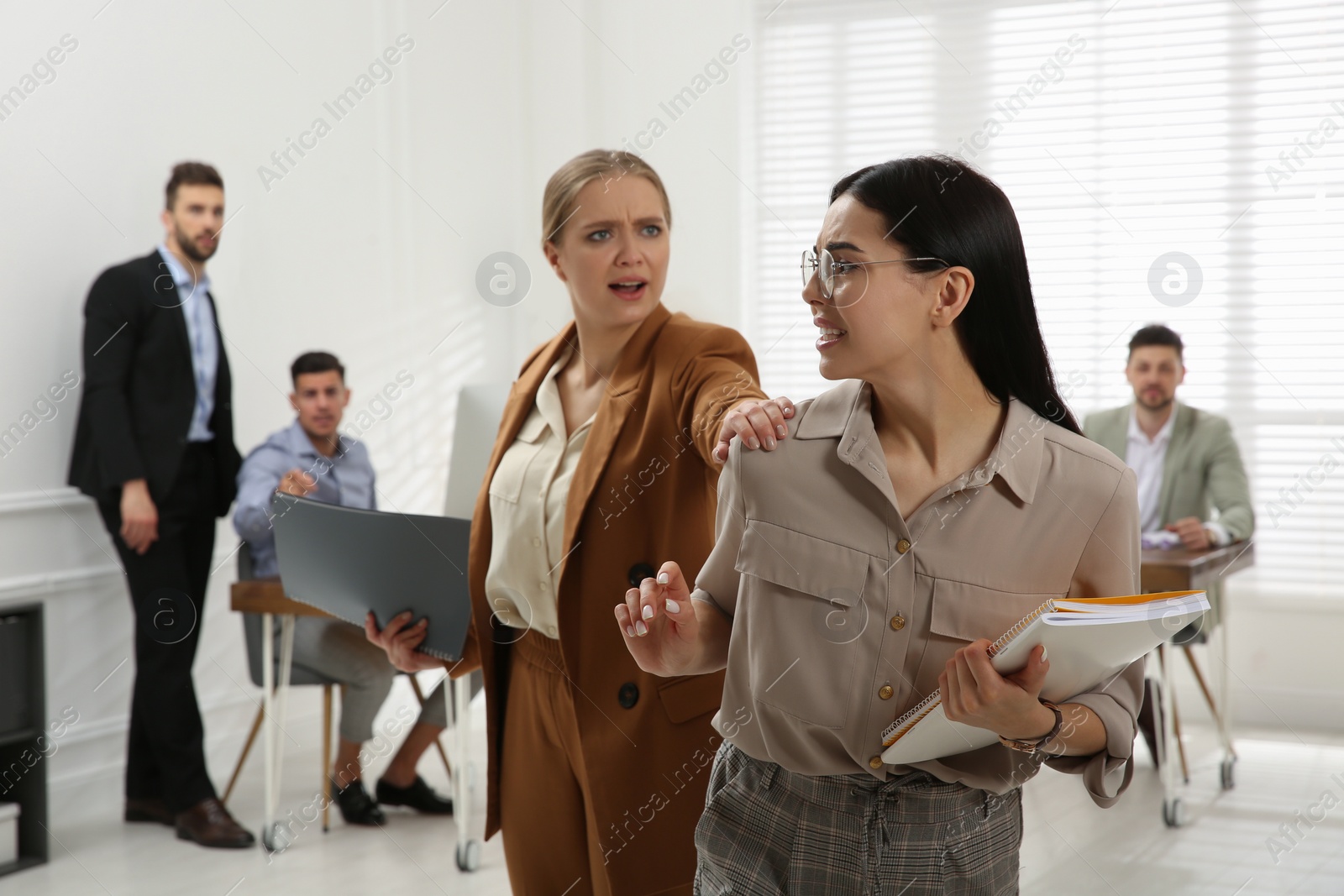 Photo of Emotional colleagues fighting in office. Workplace conflict