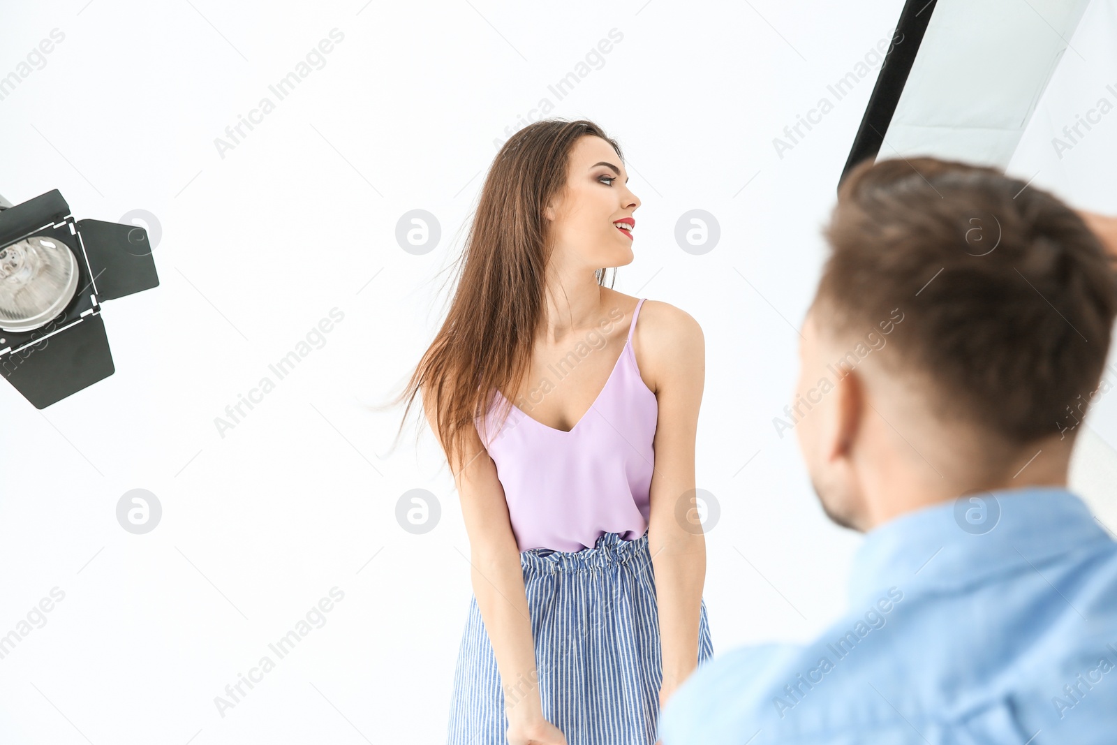 Photo of Beautiful young model posing for professional photographer in studio