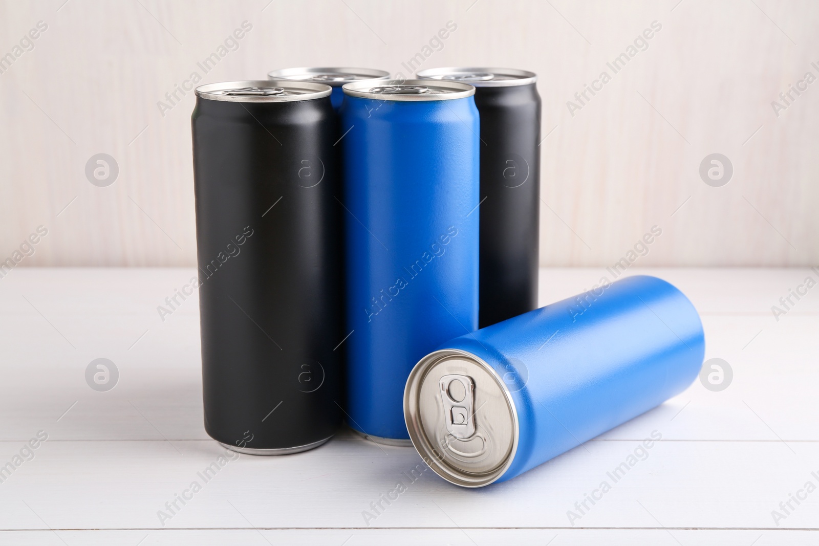 Photo of Energy drinks in colorful cans on white wooden table