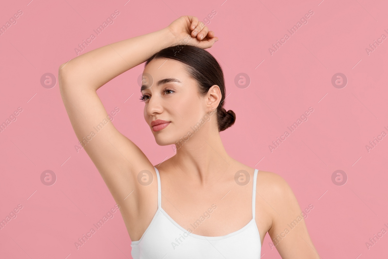 Photo of Beautiful woman showing armpit with smooth clean skin on pink background