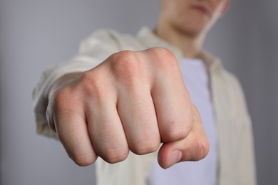 Photo of Man showing fist with space for tattoo on grey background, selective focus