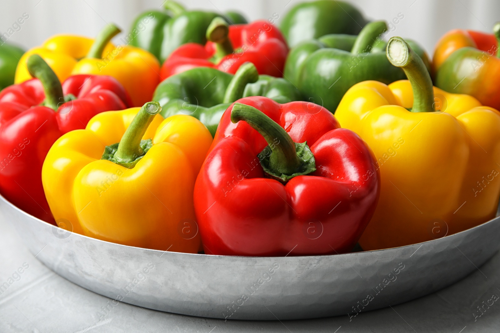 Photo of Dish with ripe paprika peppers on table