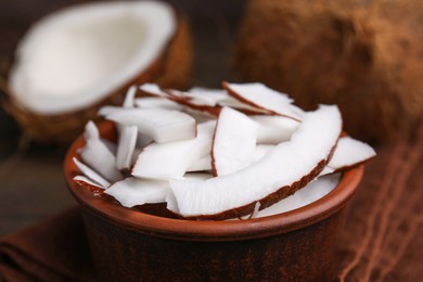 Coconut pieces in bowl on table, closeup