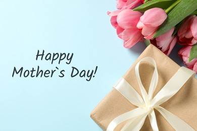 Image of Happy Mother's Day greeting card. Beautiful tulip flowers and gift box on light blue background