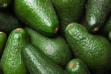 Photo of Tasty ripe green avocados as background, closeup