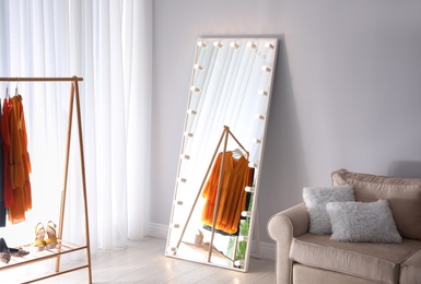 Image of Full length dressing mirror with lamps in stylish room interior