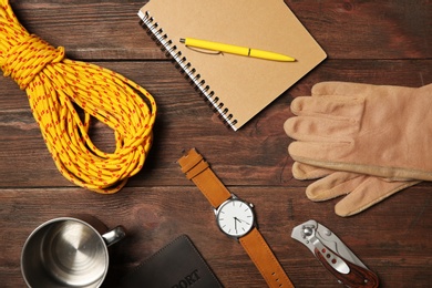 Flat lay composition with camping equipment on wooden background