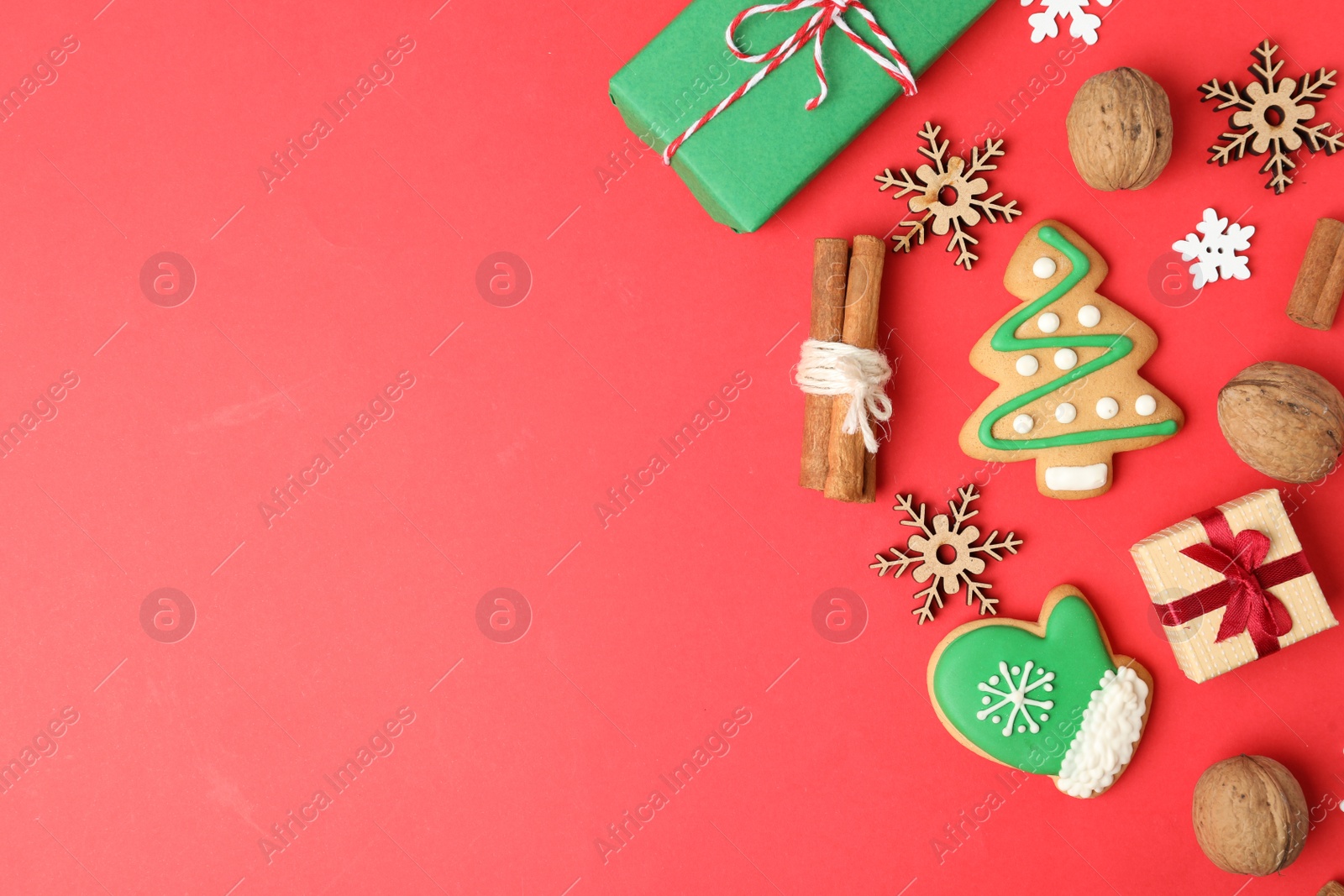 Photo of Flat lay composition with Christmas decorations and treats on red background, space for text. Winter holidays