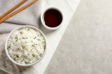 Bowl of tasty cooked rice served on table, flat lay. Space for text