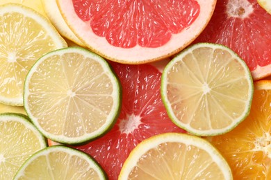 Different sliced citrus fruits as background, top view