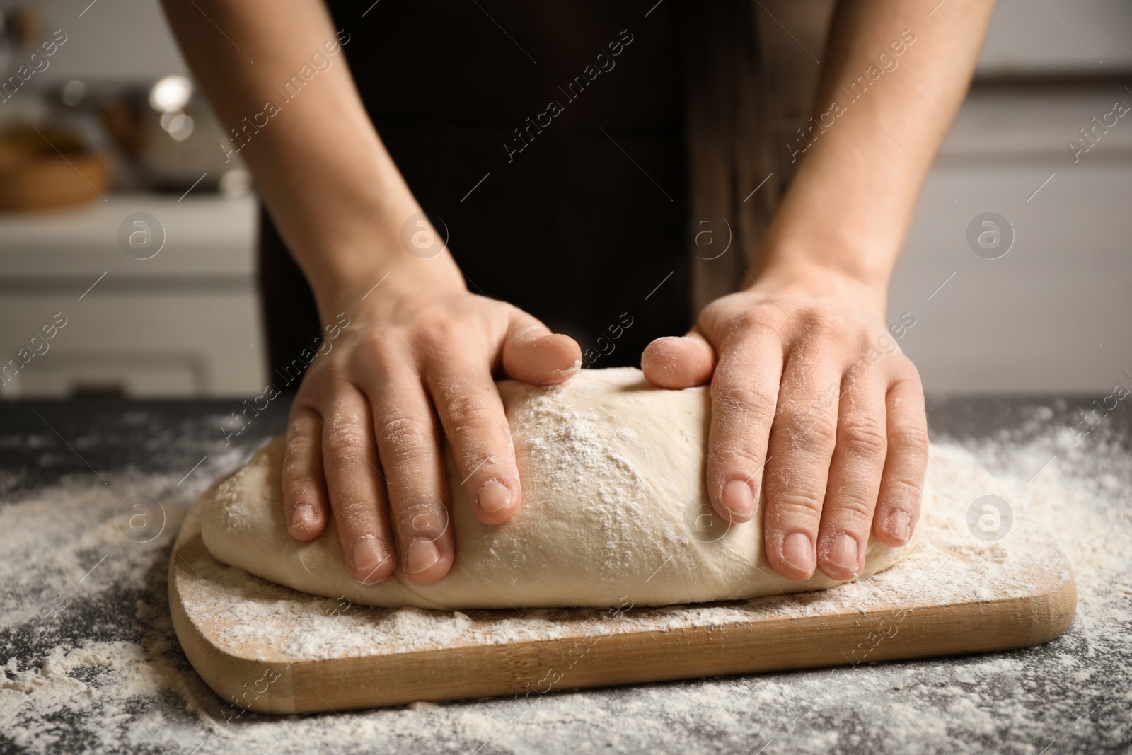 Photo of Woman with dough at grey table, closeup. Making pasta