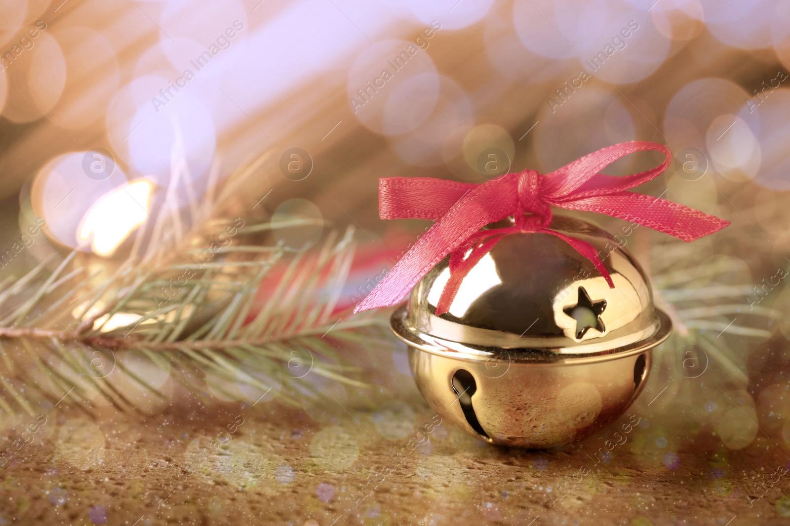 Image of Golden sleigh bells and fir branches on table, closeup