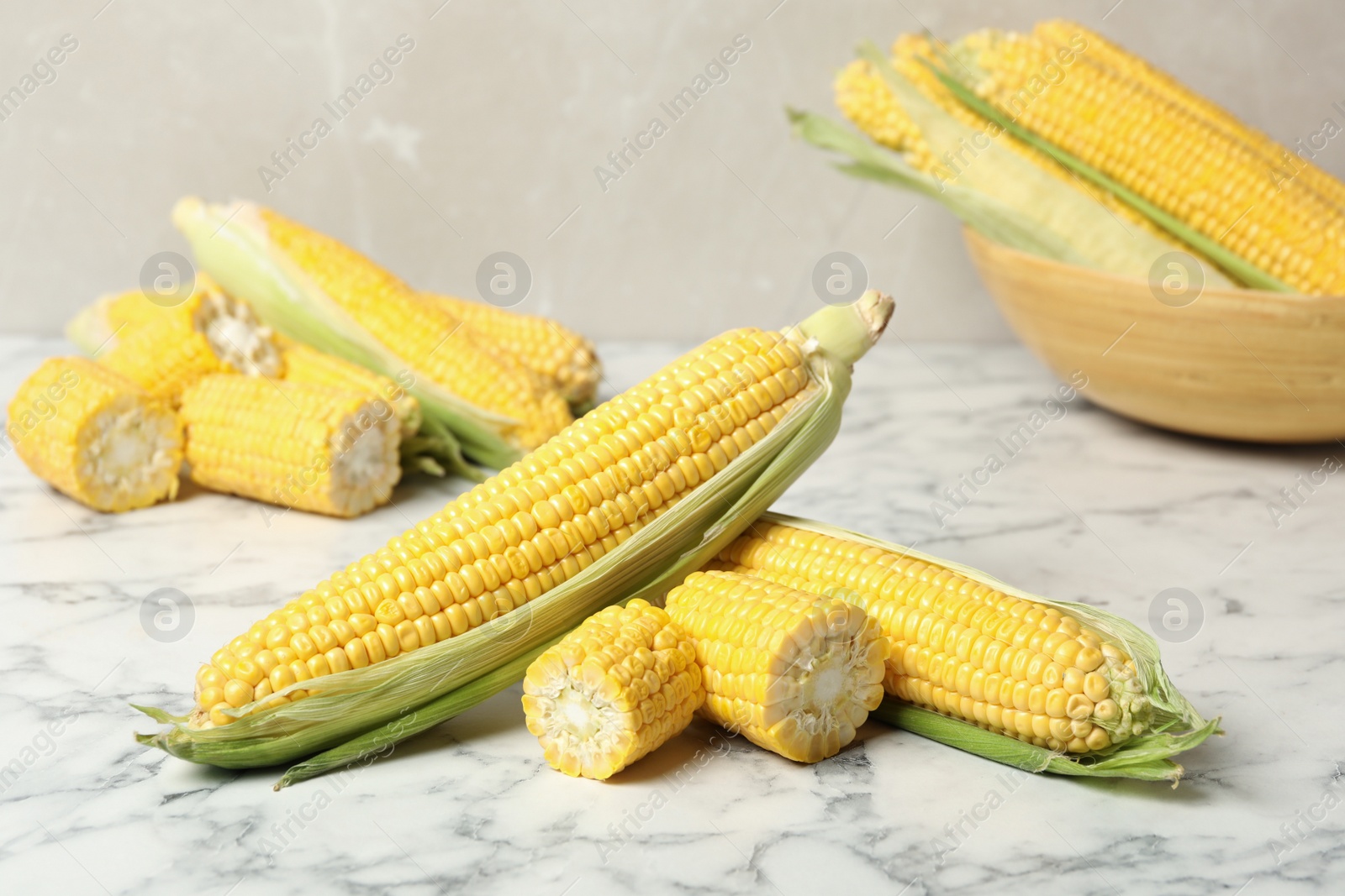 Photo of Bunch of corn cobs on white marble table