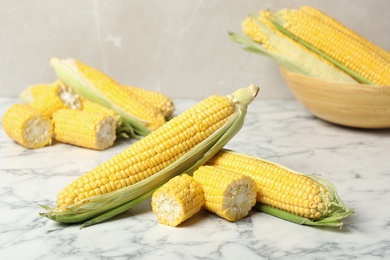 Photo of Bunch of corn cobs on white marble table