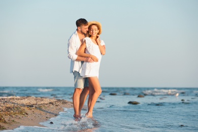 Photo of Young couple spending time together on beach